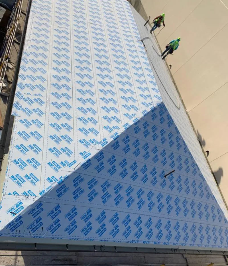 Professional roofers installing underlayment on a metal roof in Avon